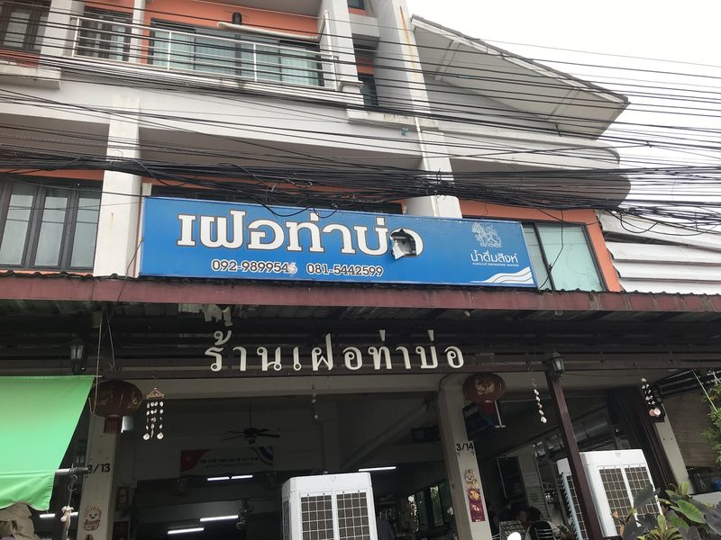 หน้าร้านเฝอท่าบ่อบนถนนศรีนวล ป้ายสีฟ้าเฝอท่าบ่อและป้ายชื่อร้านเหนือหน้าร้านที่เปิดโล่ง
